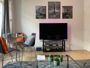 a living room with a flat screen tv on a wall at Earl Grey flat by HNFC Stays - Finest tea & Coffee in Newcastle upon Tyne