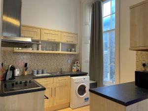 a kitchen with a washing machine and a washer and dryer at Earl Grey flat by HNFC Stays - Finest tea & Coffee in Newcastle upon Tyne +6 photos