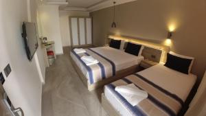 a hotel room with two beds and a tv at Seyir Village Hotel in Oludeniz