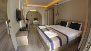 オルデニズにあるSeyir Village Hotelの大型ベッドとテレビが備わるホテルルームです。