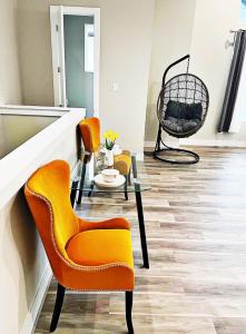 a living room with orange chairs and a table at Modern Style Relaxation in Houston, Texas in Houston