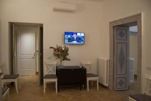 sala de estar con mesa y TV en la pared en Leoncino 36 Apartments in Rome, en Roma
