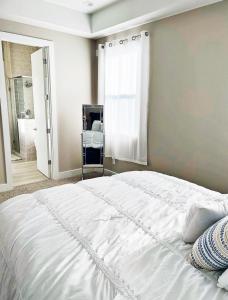 a bedroom with a large white bed and a mirror at Modern Style Relaxation in Houston, Texas in Houston