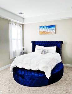 a bedroom with a large bed with a blue headboard at Modern Style Relaxation in Houston, Texas in Houston