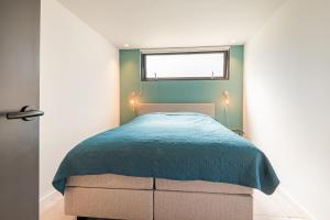 a bedroom with a bed with a blue blanket at Berger Lodge in Alkmaar