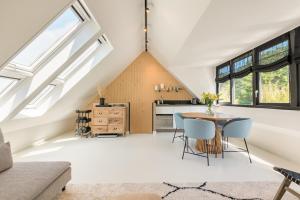 an attic kitchen with skylights and a table and chairs at Berger Lodge in Alkmaar