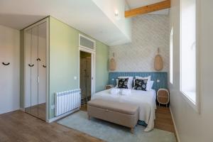 una camera da letto con un letto con cuscini di Green House By Shi Studio a Leça da Palmeira Altre 31 foto
