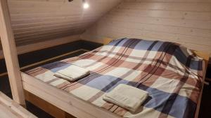 a small bed in a wooden cabin with two pillows at Zacisze u Rafała in Surmaczówka