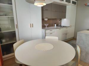 a white kitchen with a white table and chairs at Lovely cityhome in Rovaniemi