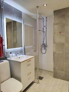 a bathroom with a white sink and a shower at Lovely cityhome in Rovaniemi