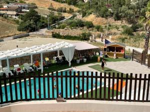 a woman standing next to a swimming pool at Imperial Park in Raffadali