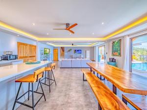 a kitchen with a long wooden table and stools at Villa AUREA Sea View in Koh Samui
