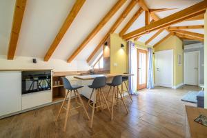 una cucina con soffitti in legno, tavolo e sgabelli di Apartments Orsula near old town a Šibenik