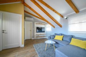 un soggiorno con un divano blu e una TV di Apartments Orsula near old town a Šibenik