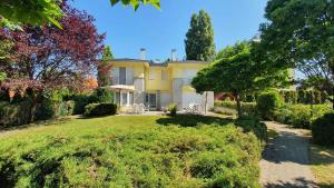 a large yellow house with trees and a yard at Holiday home in Szantod - Balaton 20221 in Szántód