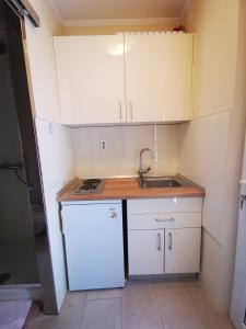 a small kitchen with white cabinets and a sink at Villa Bose- Apartmani Luka Šodan in Brela