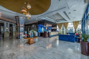a lobby of a hotel with a table and chairs at THE PARK HOTEL Formerly Al Jawhara Gardens in Dubai