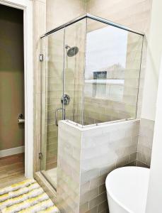 a glass shower in a bathroom with a toilet at Modern Style Relaxation in Houston, Texas in Houston