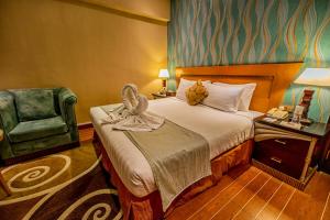 a hotel room with a bed and a chair at THE PARK HOTEL Formerly Al Jawhara Gardens in Dubai