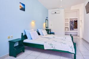 um quarto com uma cama verde num quarto em Hotel Glaros em Diafánion