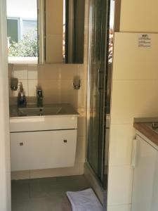 a bathroom with a shower and a sink and a mirror at Villa Bose- Apartmani Luka Šodan in Brela