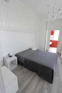 Un dormitorio con una cama grande y una lámpara de araña. en Hotel Paladini, en Porto Cesareo