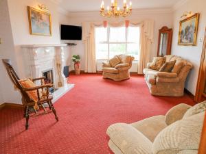 a living room with couches and a fireplace at Braeside Farm House in Ballymena