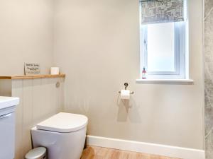 a white bathroom with a toilet and a window at Peep o' Day in York