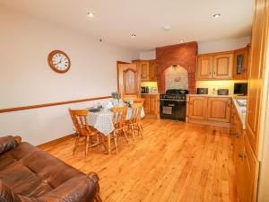 a kitchen with a table and chairs and a clock on the wall at Braeside Farm House in Ballymena