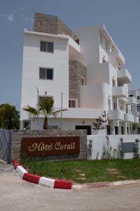 un bâtiment blanc avec un panneau devant lui dans l'établissement Hôtel Corail de Cabo, à Cabo Negro