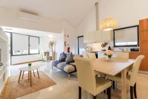 a dining room and living room with a table and a couch at Casa do Casal - Country House with Swimming Pool in Viana do Castelo
