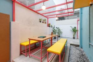 a room with a table and two yellow chairs at Locul Midtown-Indiranagar in Bangalore