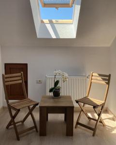 um quarto com duas cadeiras, uma mesa e uma clarabóia em Vila San Nicoara em Curtea de Argeş