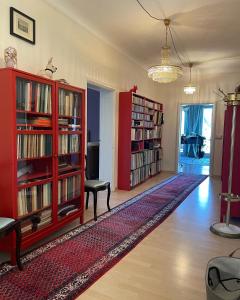 a living room with red bookshelves and a table at Musikalische Ferienwohnung mit Rheinblick in Sankt Goar