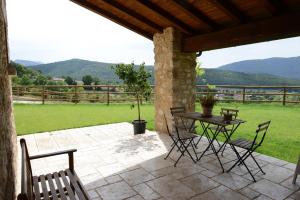 eine Terrasse mit einem Tisch, Stühlen und einem Zaun in der Unterkunft Casale dei Briganti in Norcia