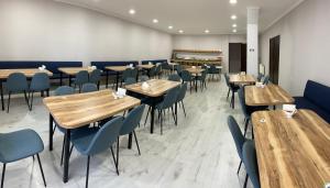 a dining room with wooden tables and chairs at Hotel Sani Kutaisi in Kutaisi