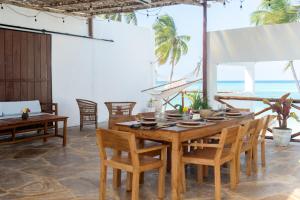 a dining room with a table and chairs and the ocean at Coco Rise Villas - Villa Dining Service Available in Bwejuu