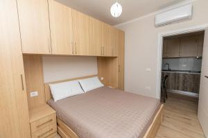 a small bedroom with a bed and wooden cabinets at Curoj Luxury Apartments in Radhimë