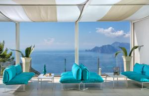 a room with blue chairs and a view of the ocean at Relais Blu in Massa Lubrense