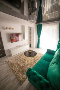 uma sala de estar com um sofá verde e uma mesa em Toto’s Apartment em Constança