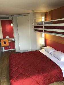 - une chambre avec un grand lit et une couverture rouge dans l'établissement Premiere Classe Laon, à Laon