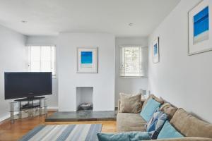 a living room with a couch and a flat screen tv at The New Pin in St Ives