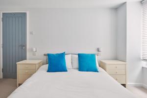 1 dormitorio con 1 cama blanca grande con almohadas azules en The New Pin, en St Ives