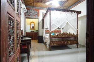 een slaapkamer met een hemelbed en een spiegel bij Okawati Boutique Bungalows in Ubud