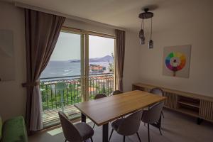 a dining room with a table and a large window at Vertmont Villa in Sveti Stefan