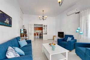 una sala de estar con sofás azules y una mesa. en Villa Alexis House by Villa Plus, en Kalo Chorio