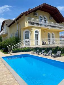 una casa con piscina frente a una casa en Royal Villa, en Balatonfüred