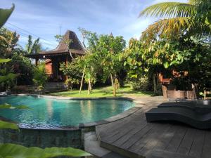 a swimming pool in front of a house at Mirah Guest House in Tampaksiring
