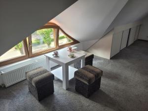 Una habitación con una mesa blanca y dos taburetes. en Pokoje Gościnne Strażnica, en Jarosławiec