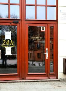 a red door of a building with a sign in it at APARTAMENTY T.R.11 Apartament nr 3 in Olsztyn